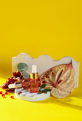 Composition with bottles of essential oil and plaster decor on yellow background
