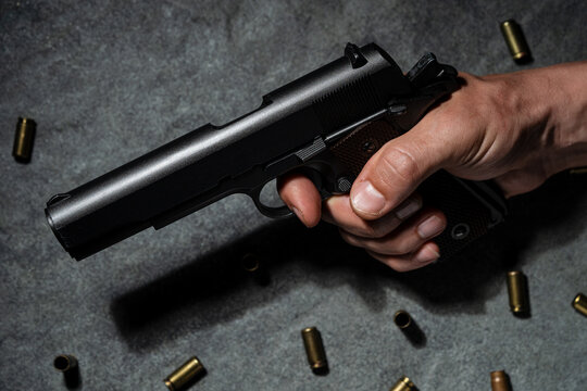 Close up of male hand holding a pistol.