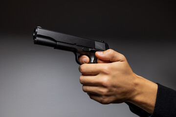 Close up of man hand with aiming gun.