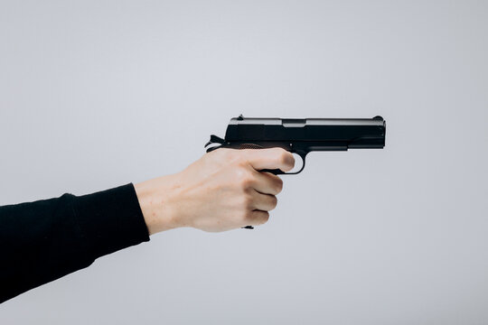 Close up of man hand with aiming gun on white background.