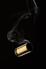 Cartridge cases with smoke falling on black background
