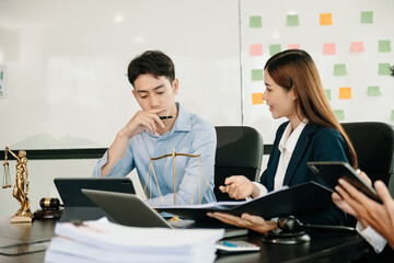 Asian business team and lawyers discussing contract papers sitting at the table. Concepts of law, advice, legal services. at office