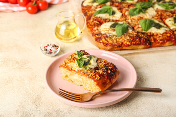 Plate of tasty Italian pie with mozzarella and pesto sauce on light background