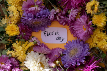 Inscription day of the florist surrounded by different flowers. Florist's holiday. Greeting card. Floral background.