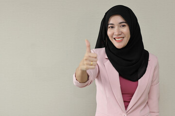 Happy smart asian business woman in muslim dress standing and showing thumb up with confident in studio. Isolated white background portrait beautiful face in hijab. Advertisement portrait concept