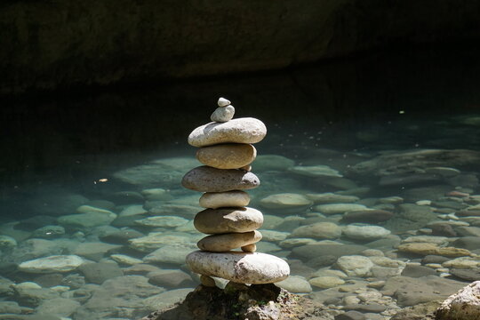 Pietre accatastate in riva a un fiume che simboleggiano l'equilibrio