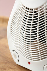 Electric fan heater near pink wall, closeup