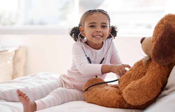 Children, stethoscope and teddy bear with a girl playing doctor in her bedroom at home with a stuffed animal. Imagination, healthcare and medicine with a cute female child being a pretend nurse