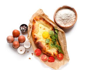 Tasty Ajarian khachapuri, eggs, spices and flour on white background