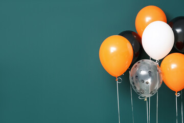 Halloween balloons near green wall