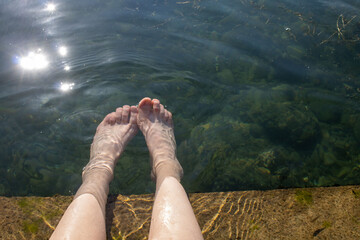 Klares  pures See Wasser ,meine Füsse in Wasser,Reflektion in Wasser von Sonne