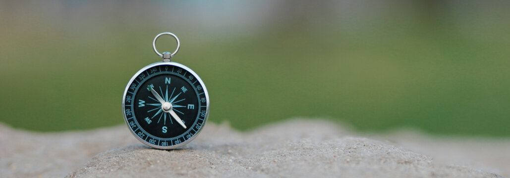Classic compass on vintage wood with green background. Symbolic compass of compass travel. travel with compass concept of economic and environmental direction.