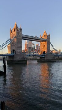 Exploring London and walking by Tower Bridge into sunset time. Walking around River Thames towards Tower Bridge into early morning golden sunrise sunlight painted the tower in London, England, UK