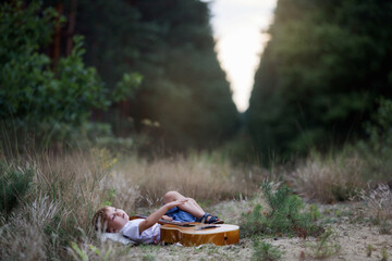Chłopiec leży na trawie i gra na gitarze - obrazy, fototapety, plakaty