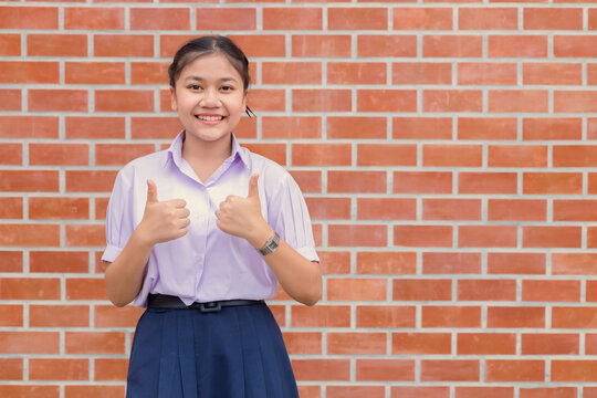 Asian school girl two thumbs up gesture happy enjoy for good education learning concept