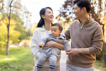 Young parents playing with baby in park