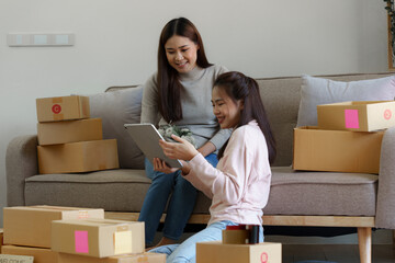 Asian SME business woman with partner working at home office. online shopping concept