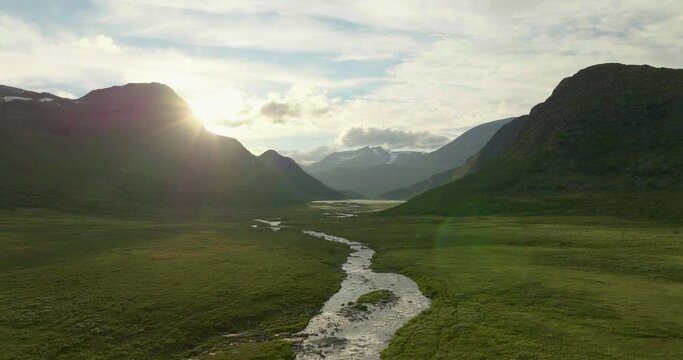 Bright Sun At Dusk Shining Over A Valley In Jotunheimen Mountain Range In Norway. - aerial, slow motion