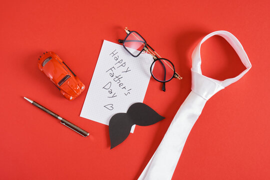 happy father's day lettering on paper, tie, trendy funny glasses, toy car, pen, mockup notepad and mustache,
