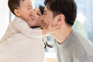 Young parents playing with baby at home
