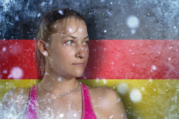 Obraz premium Young woman on frozen background with flag of Germany. Concept of crisis in Europe in winter. Energy crisis.