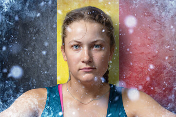 Young woman on frozen background with flag of Belgium. Concept of crisis in Europe in winter. Energy crisis.