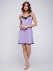 High fashion photo of a beautiful elegant young woman in a pretty soft purple nightgown posing over white background. Slim figure. Studio Shot.  Pastel 