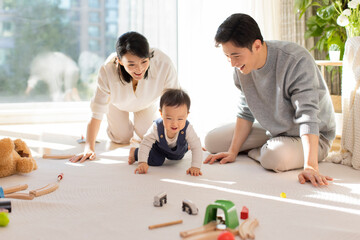 Young parents playing with baby at home