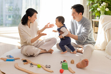 Young parents playing with baby at home