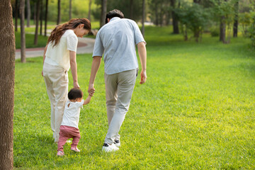 Young parents playing with baby in park