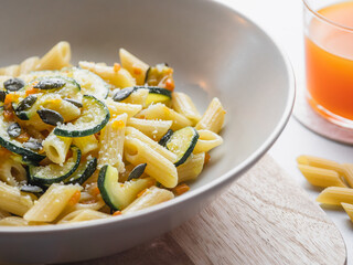 Dish of penne pasta with zucchini, seeds and parmisan. close up. Carbo portion ready for eat. Italian food, healthy vegetarian food. vegetable recipe for diet