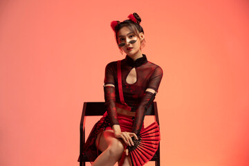 Beautiful young woman holding a fan