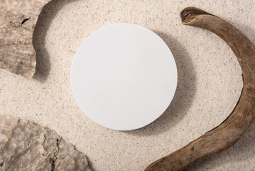 Natural cosmetic background for product presentation. Rocks, driftwood and white podium on the...