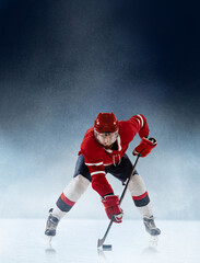 Face-off. Professional ice hockey player in action on white blue snow backgound. Winter sports, competitions, energy, power