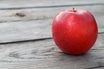 Red ripe apple on a rustic gray wooden boards. Copy space