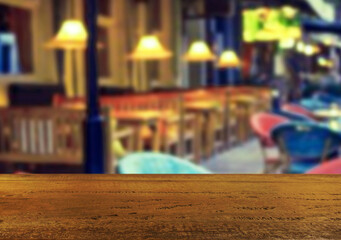Wooden table top on blur night restaurant or cafe background.For montage product display or design key visual layout.View of copy space.