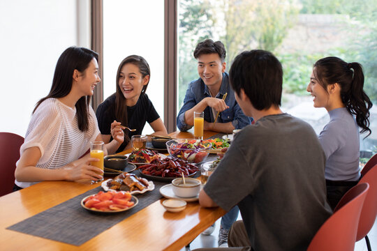 Young friends dining together at home