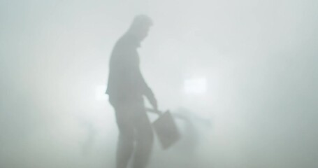 A visual effects specialist creates a dense fog with a foghorn before filming.