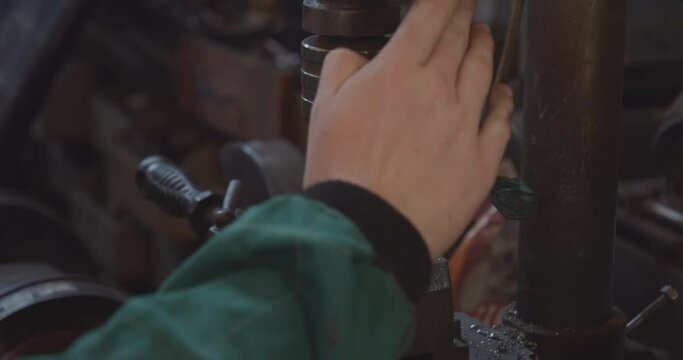 Detail of the drill bit of the bench drill in the workshop with which the mechanic works