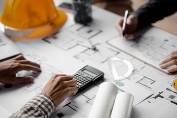 Architects and engineers are working together to edit the draft house plan that was designed after...