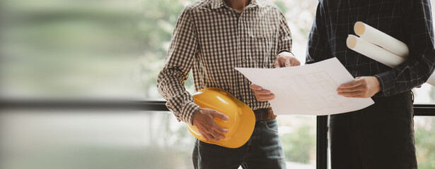 Two architects and engineers are in a meeting to discuss house designs according to building and construction standards before presenting them to clients. Interior design and decoration ideas.