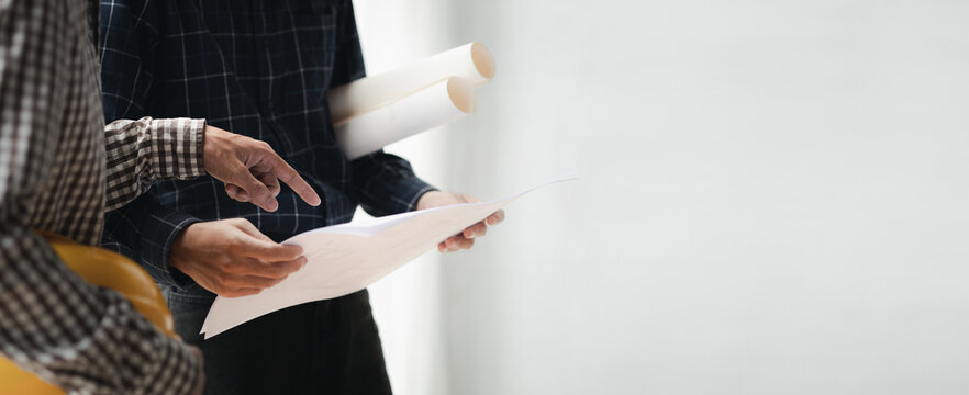 Two architects and engineers are in a meeting to discuss house designs according to building and construction standards before presenting them to clients. Interior design and decoration ideas.