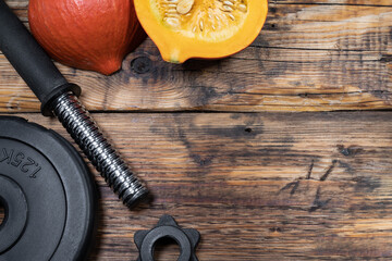 Dumbbell barbell weight plate and Hokkaido pumpkin. Healthy fitness lifestyle autumn fall...