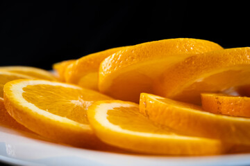 orange slices on a white plate. dark background