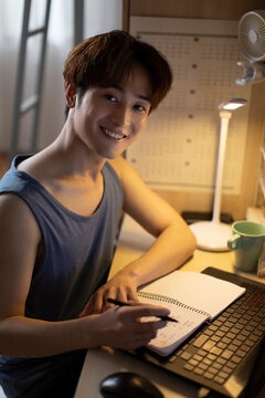 Young University Student Using Laptop In Dormitory