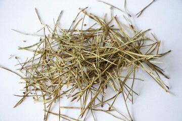 Pile of pine needles on a white background. Dried needles of conifers to make a healthy tea
