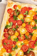Puff pastry pie with colorful tomatoes and mozzarella, parsley and basil