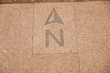 sign indicating North engraved on a granite slab, direction sign