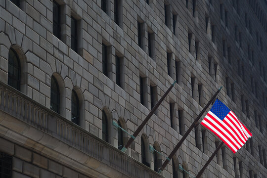 Federal Reserve building & American Flag, New York. Building in shadow with only the american flag in full light