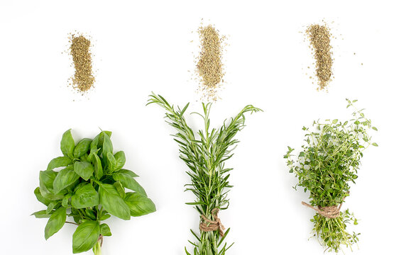 Bunches of thyme, basil and rosemary and dry spices on white background